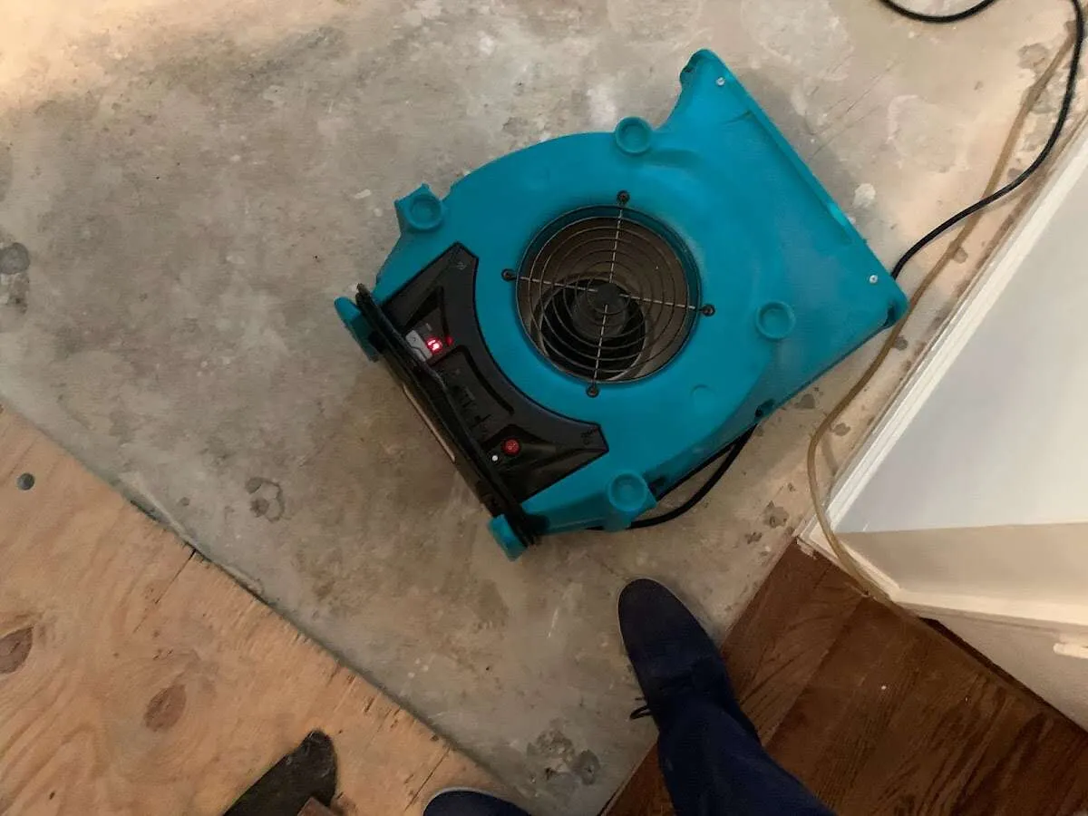 Air mover drying subfloor during Leak Detection & Repair in Liberty